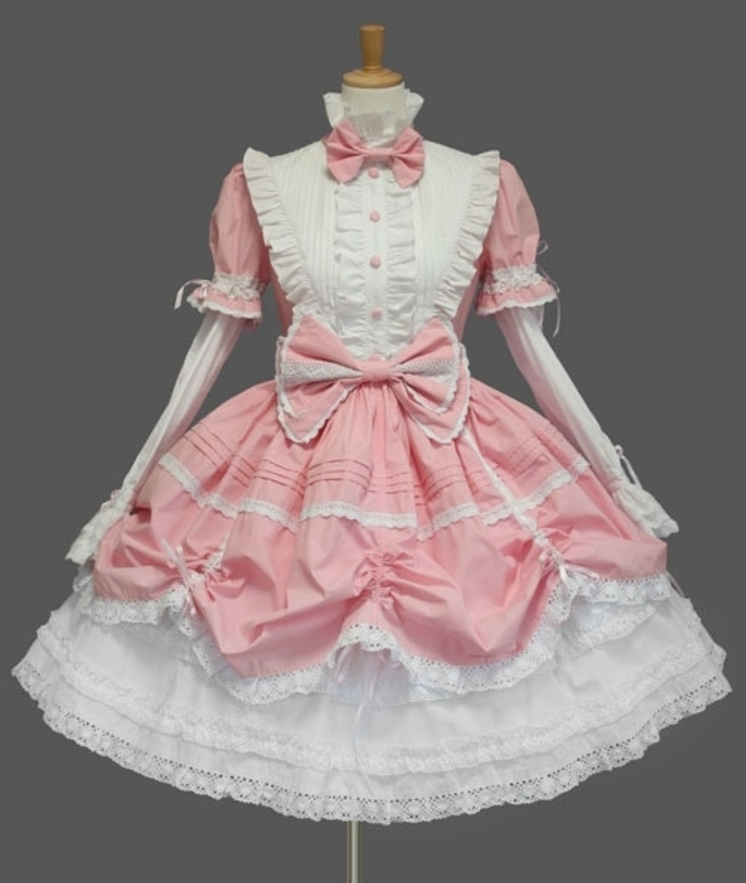 Pink and white dress with white ruffle and a large pink bow on the front