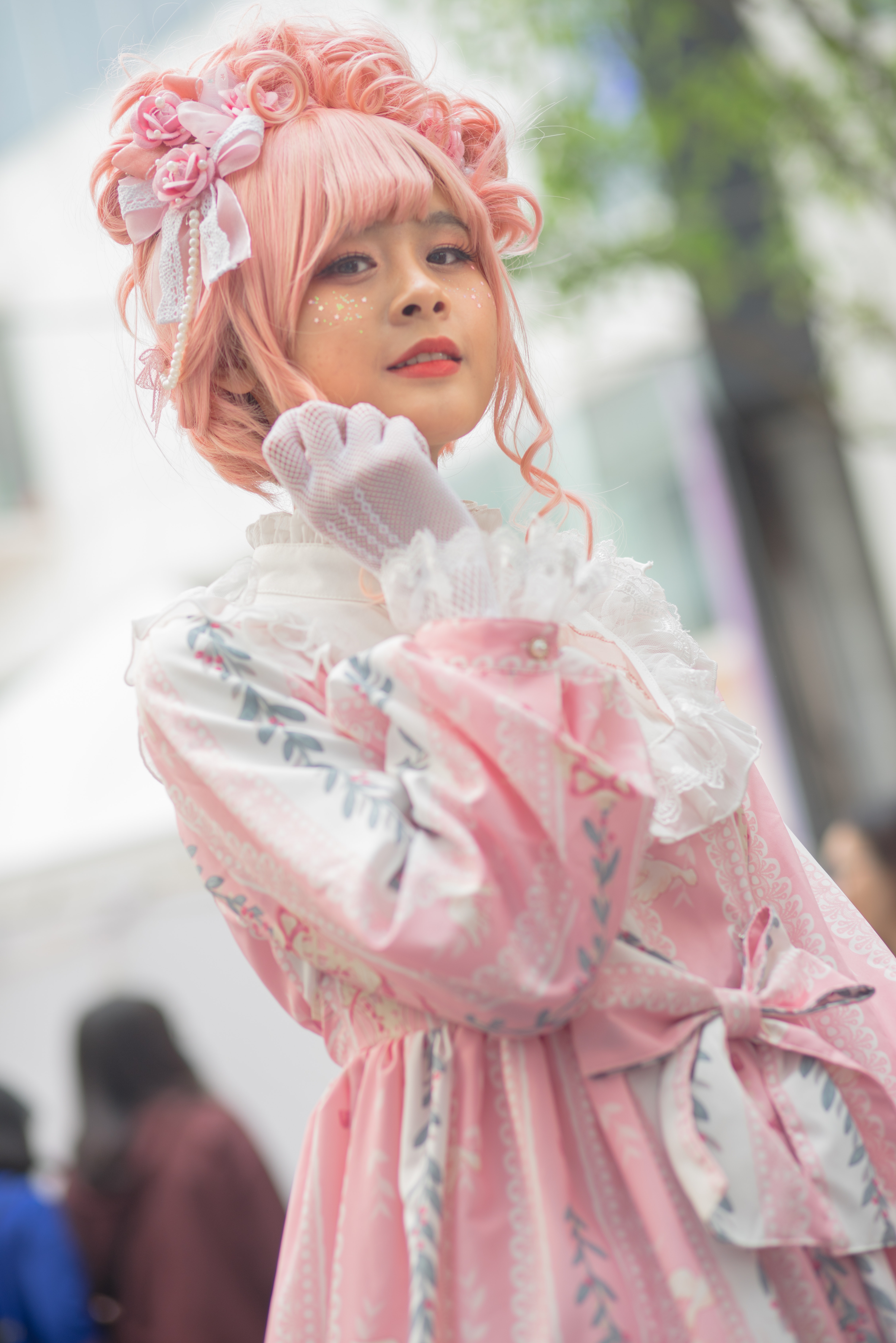 A Japenese girl with pink hair wearing a pink dress.